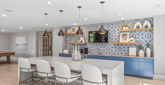 a kitchen with blue cabinets and a white island with chairs at Central Island Square, Charleston, 29492