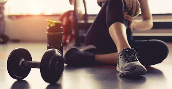 Woman Sitting on Floor Taking Break from Working Out