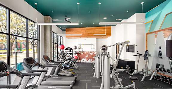 a gym filled with cardio equipment and weights
