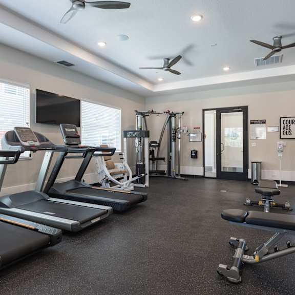 an exercise room with treadmills and weights and a tv at Heritage Landing Apartments, Chico, 95973