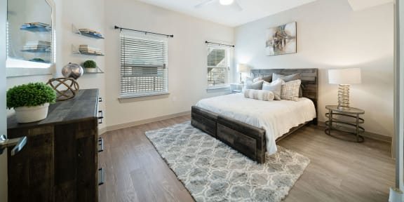 a bedroom with a bed and two windows