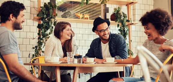 Four people are sitting around a table in a restaurant.