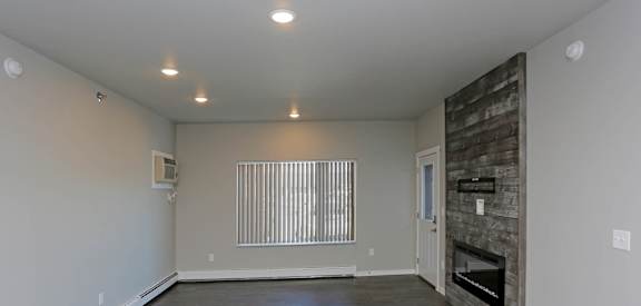 the living room with a fireplace in a bedroom plus den unit.