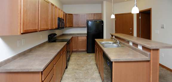 a kitchen with wood cabinets and black appliances