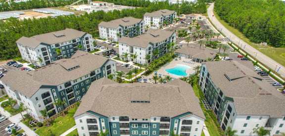 an aerial view of an apartment complex with a swimming pool and parking lot at Fountainhead, Jacksonville, 32258