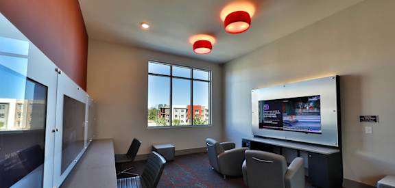 a room with couches and chairs and a flat screen tv at Luxor Club, Jacksonville Florida