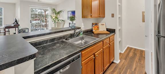 A kitchen with wooden cabinets and a black counter top.