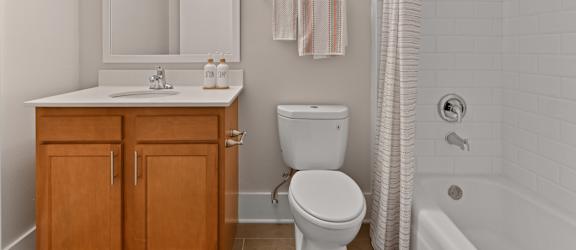 a bathroom with a toilet and a sink and a shower at Fox Run Apartments, St. Charles