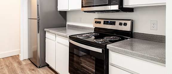 a kitchen with white cabinets and stainless steel appliances and a microwave