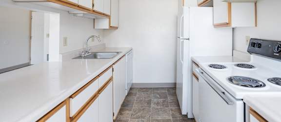 A kitchen with white appliances and white countertops.
