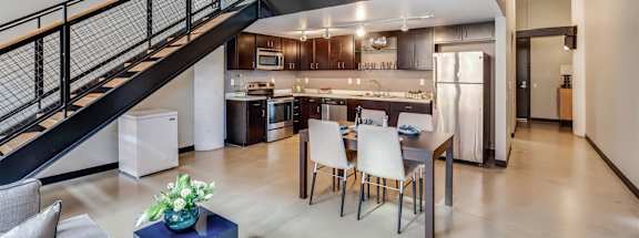 A modern open concept living space with a kitchen in the background.
