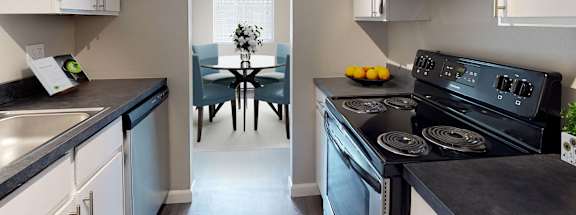 A kitchen with black countertops and white cabinets.