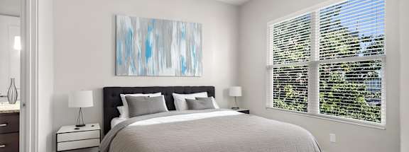 State Street Flats Apartments bedroom with a large bed and a ceiling fan.