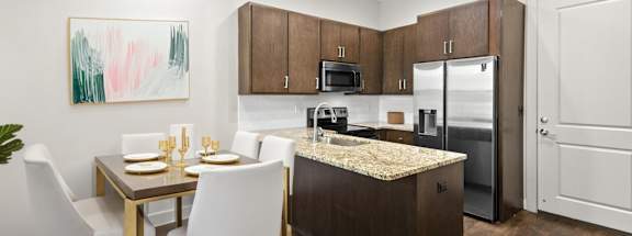 State Street Flats Apartments modern kitchen with a dining table set for two.