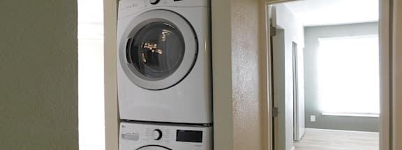 Two white front loading washing machines in a laundry room.