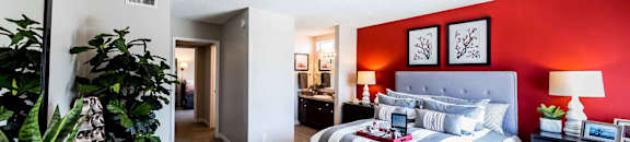 bedroom with dresser and bed with bathroom and hallway in background at CASA GRANDE APARTMENT HOMES, Cypress, California