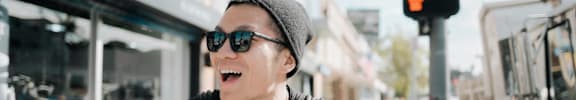 Man Standing Outside Wearing Beanie and Sunglasses Smiling