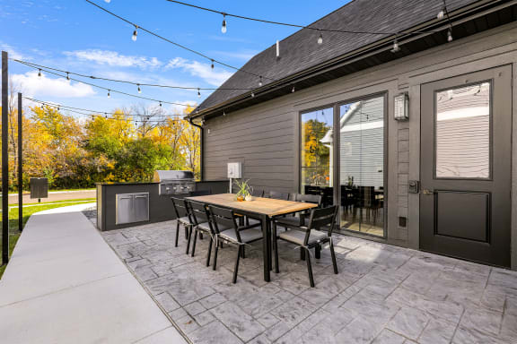 the back patio with a table and chairs and a grill