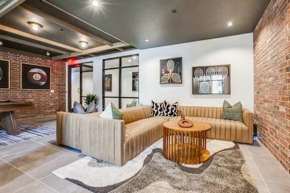 A living room with a tan couch and a wooden coffee table.