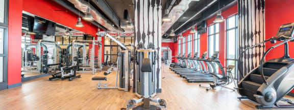 an image of a gym with hardwood floors and a red wall