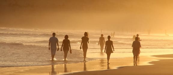 a group of people laughing and talking at the beach
