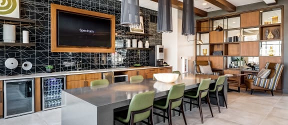 a kitchen with a long island with green chairs at Icon Apartment Homes at Ferguson Farm, Bozeman, Montana