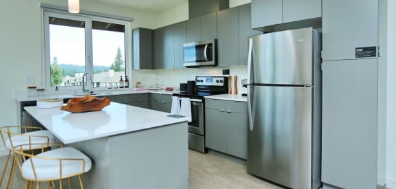 a modern kitchen with stainless steel appliances and gray cabinets