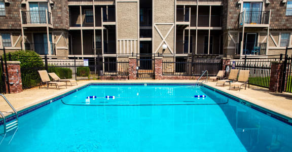 a large pool with an apartment building in the background