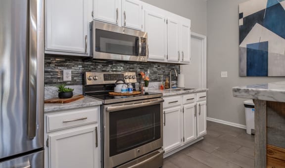 Sterling Park apartments kitchen with white cabinets and stainless appliances