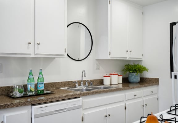 a kitchen with white cabinets and a granite countertop