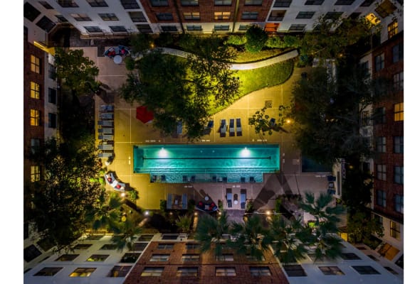 an aerial, night-time view of the swimming pool at The Core apartments