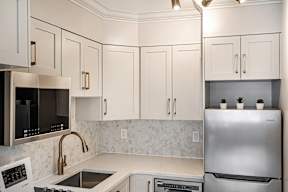 A kitchen with a stainless steel refrigerator, microwave, and oven.