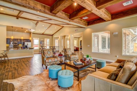 a living room with a coffered ceiling and a kitchen in the background at Villa Espada Apartments, San Antonio, Texas