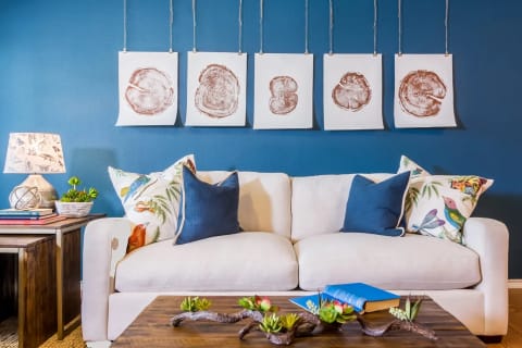 a living room with blue walls and a white couch at Villa Espada Apartments, San Antonio, Texas