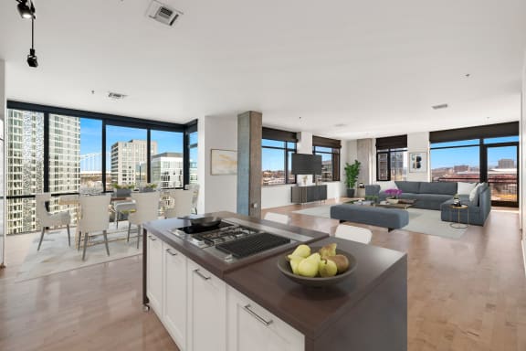 a kitchen with a large island next to a living room with a couch and a table