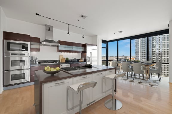 a kitchen with a large center island with a breakfast bar and a dining room with a table