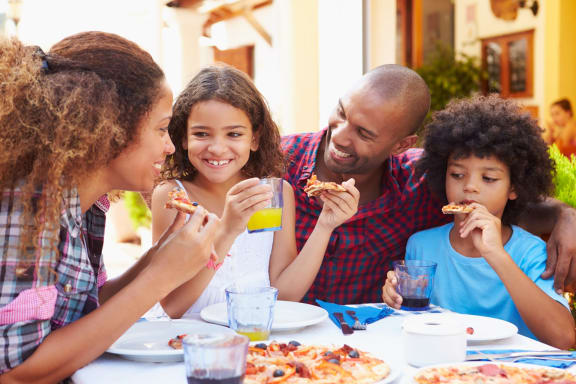 Young Family Having Dinner Together Smiling