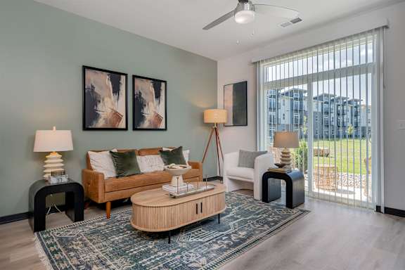 A living room with a couch, two chairs, a coffee table, and a rug.