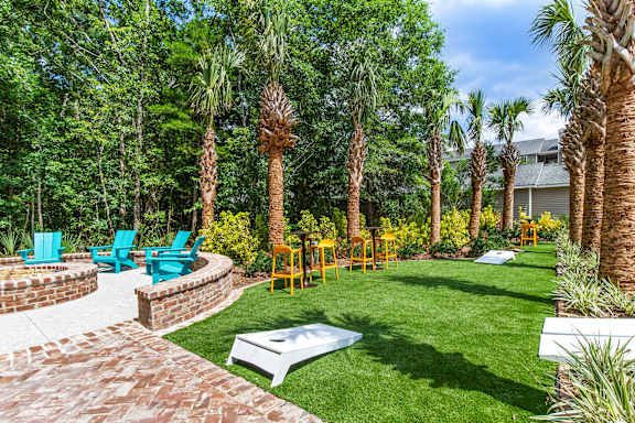 A backyard with a white table surrounded by palm trees.