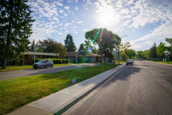 a city street with a house and cars on the side of the road