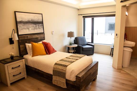 a bedroom with a bed and a chair