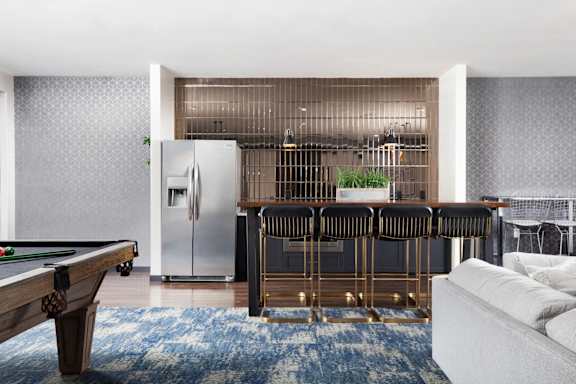 A modern living room with a pool table and a bar area.