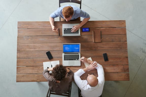 people sitting at a table with laptops