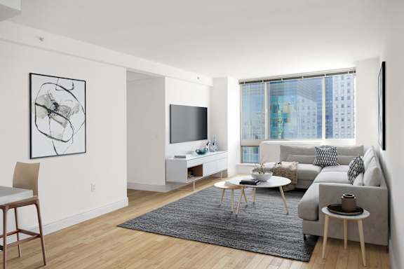 A modern living room with a grey couch, a coffee table, and a television.at 'The Metropolis', New York, 10017