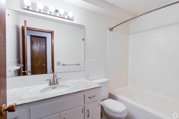 A white bathroom with a sink, toilet, and bathtub.