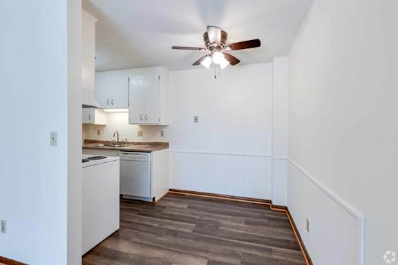 A kitchen with white cabinets and a dishwasher.