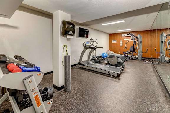a gym with weights and a tv in the corner