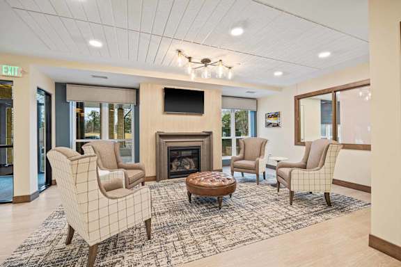 A living room with a fireplace and chairs.