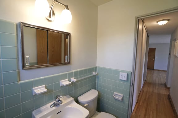 a bathroom with a toilet sink and mirror
