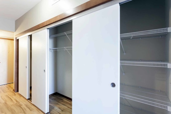 a wardrobe with sliding doors in a room with a wood floor
